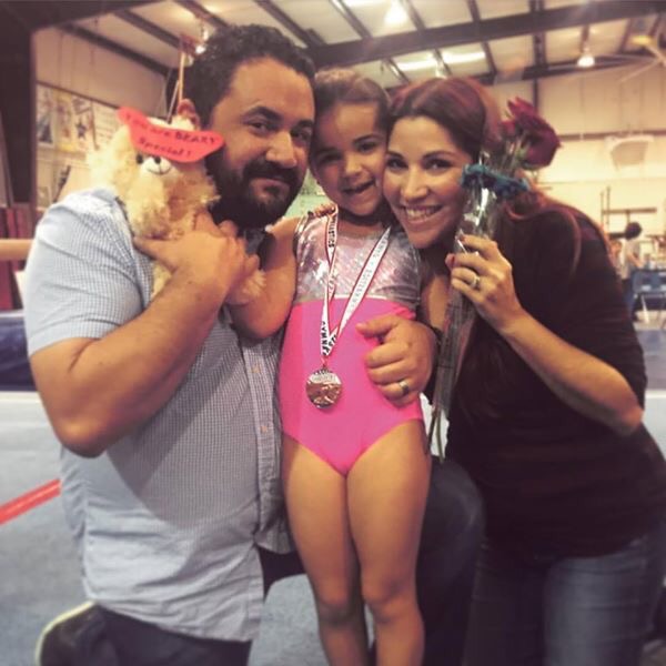 Parents and daughter with gymnastics medal