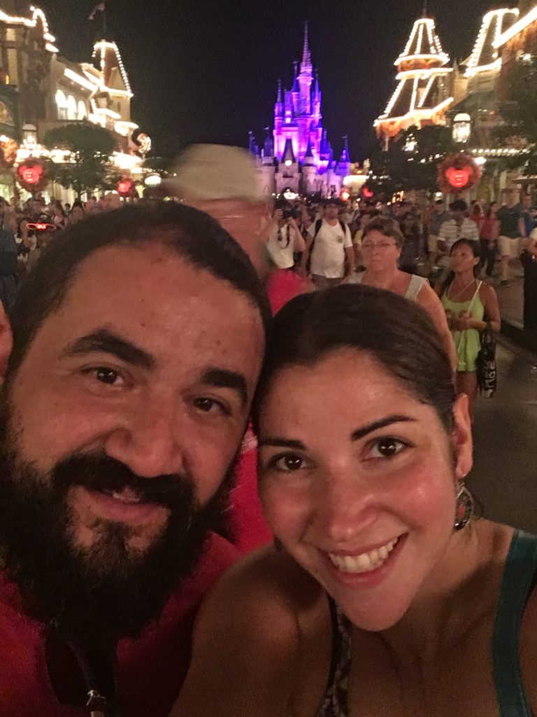Happy couple Adam and Coppelia smile with the Cinderella Castle behind them at the Magic Kingdom 2016