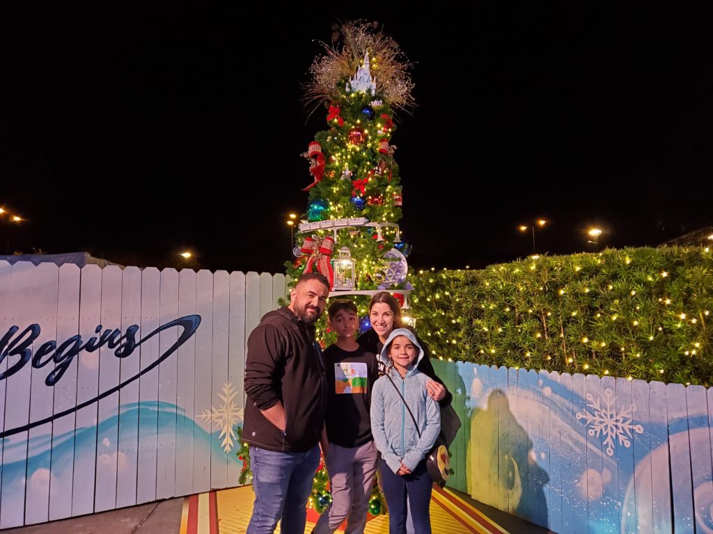 Family in front of the Disney Parks Christmas Tree at Disney Springs Trail of Trees