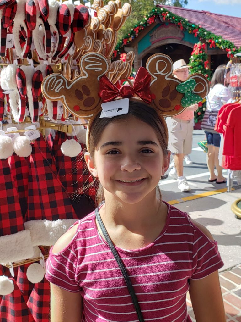 Cute girl wearing Gingerbread Mickey and Minnie Ears at Disney Springs Trail of Trees