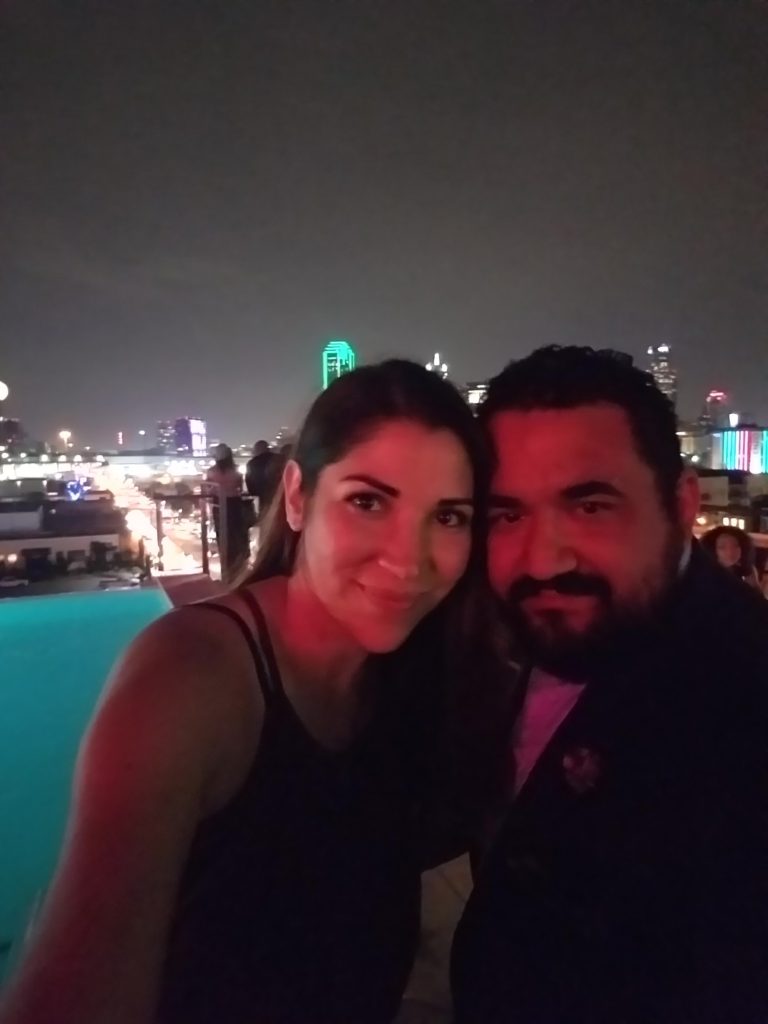 Experience Gifts for Valentine's Idea: Couple smiling on a rooftop with the Dallas skyline in the background